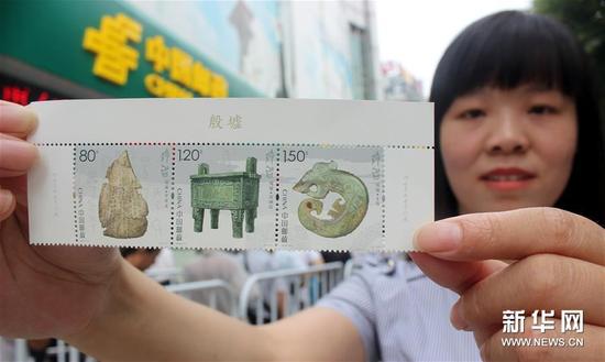 7月13日，一名集郵愛(ài)好者在江蘇蘇州郵政局展示剛購(gòu)買的《殷墟》特種郵票。
