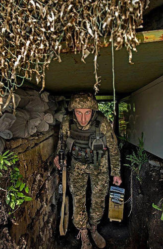 分別手持AK步槍和彈藥箱的烏政府軍士兵在掩體中留影。