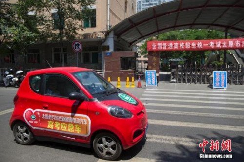 一輛新能源電動(dòng)汽車高考接送車從山西太原某考點(diǎn)前駛過(guò)。<a target='_blank' href='http://www.chinanews.com/'>中新社</a>發(fā) 張?jiān)?攝