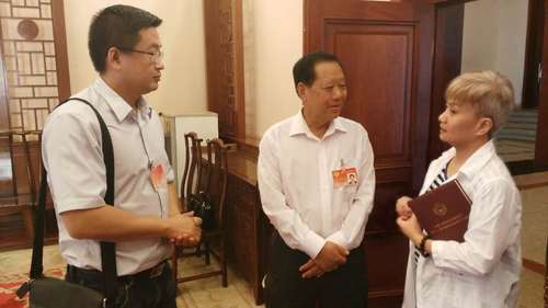 全國政協(xié)副主席劉曉峰（中）了解報(bào)道情況
