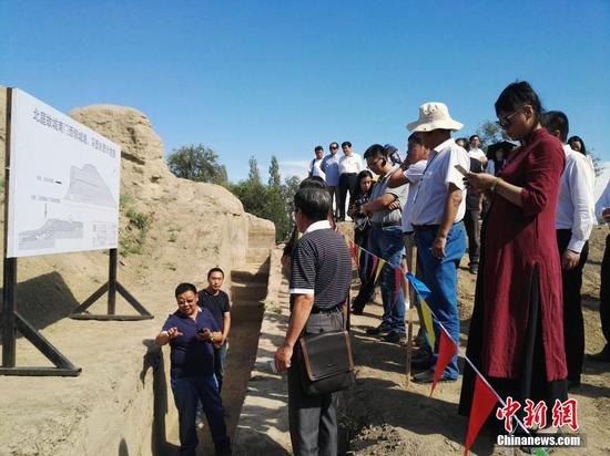 圖為專家現(xiàn)場講解北庭故城南門西側(cè)城墻文物挖掘情況。中新社記者 王小軍 攝