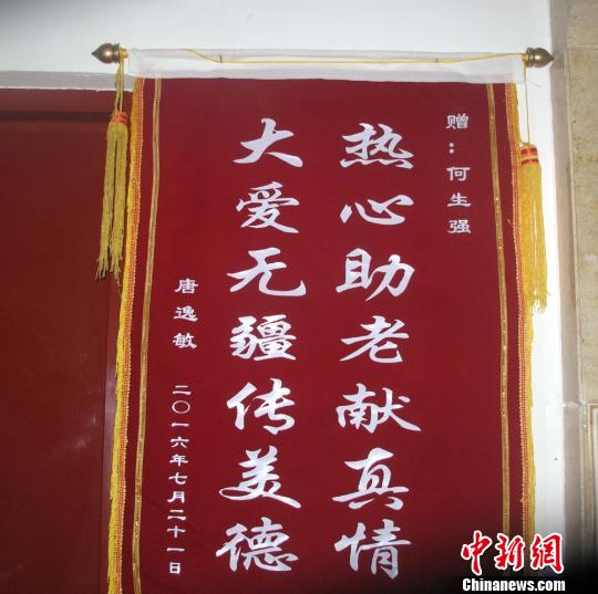 唐逸敏侄女贈(zèng)送的錦旗掛在社區(qū)走廊的墻壁上?！顤| 攝
