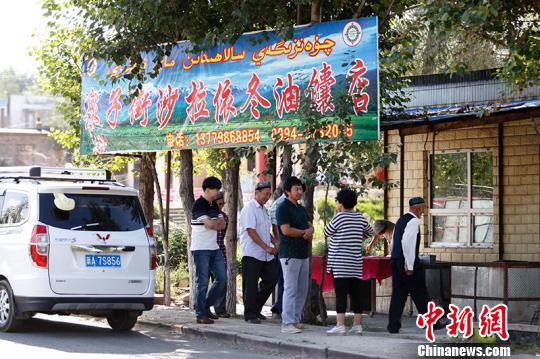 每天前來(lái)買馕的人在馕炕前排隊(duì)?！⊥跣≤?攝