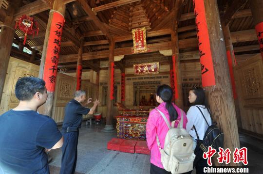 　　圖為70余歲的退休教師林樂妙（左二）擔(dān)任起普照堂的“講解員”，每天義務(wù)為外地來的游客追古溯今?！埍蟆z