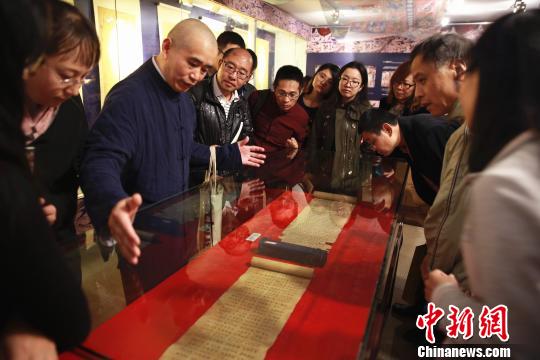 敦煌卷子珍品吸引眾多觀眾，學(xué)者正在講解其中奧妙?！〈麋鳌z