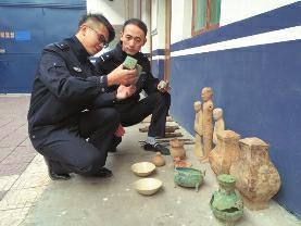 昨日，興平市公安局刑偵大隊東城中隊，民警查看被追繳回來的文物 華商報記者 薛望 攝