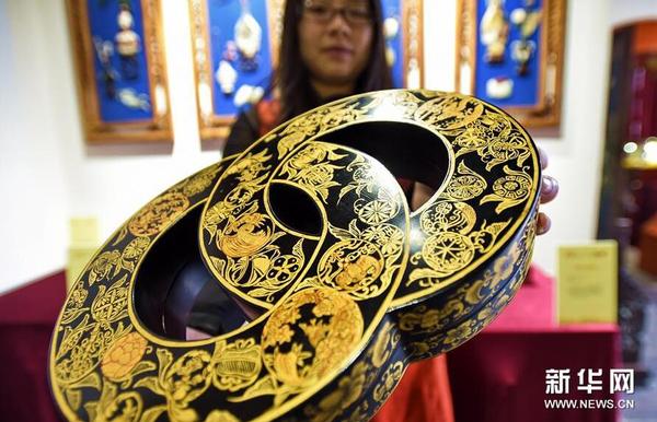 11月13日，北京金漆鑲嵌有限責(zé)任公司工作人員展示“黑漆描金雙圓盒”。