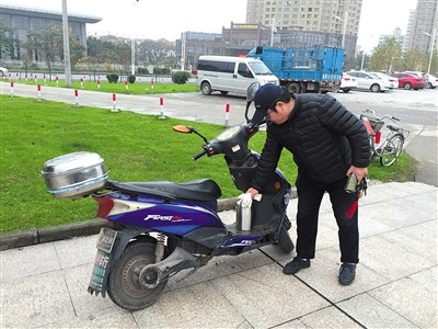 11月20日，陳思騎電動車巡江。由于每次出去就是一整天，他都會自備一個水壺。