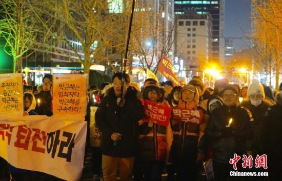 當(dāng)?shù)貢r(shí)間12月10日，韓國民眾舉行“親信干政”事件后第七輪大規(guī)模集會(huì)。雖然前一日韓國國會(huì)通過總統(tǒng)彈劾案，樸槿惠已被暫?？偨y(tǒng)職權(quán)，但示威民眾仍高喊口號(hào)，要求樸槿惠立即下臺(tái)。當(dāng)日也有“親樸派”市民團(tuán)體舉行游行，反對(duì)彈劾案，稱“彈劾無效”。中新社記者 吳旭 攝