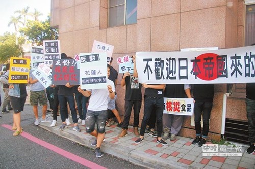 日本核災(zāi)食品輸臺公聽會花蓮場爆發(fā)沖突，場外有反對民眾持標(biāo)語抗?fàn)帯?圖片來源：臺灣《中國時報》)