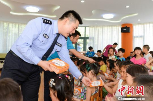 民警向小朋友發(fā)放反拐常識畫冊。陜西警方 供圖