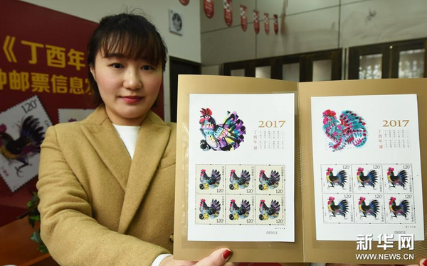 1月3日，杭州郵票公司工作人員展示即將發(fā)行的《丁酉年》生肖特種郵票。（新華社發(fā) 龍巍攝）