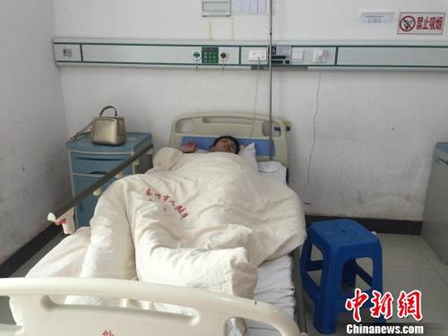 2月12日，廣西東興市人民醫(yī)院住院部病房內，遭越南邊防人員毆打致傷的中國游客謝某躺在病床上。　陳燕 攝