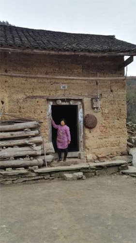 姚永勝老家的房子，他的母親站在門口，還不知道兒子死亡的消息。圖片由村民提供