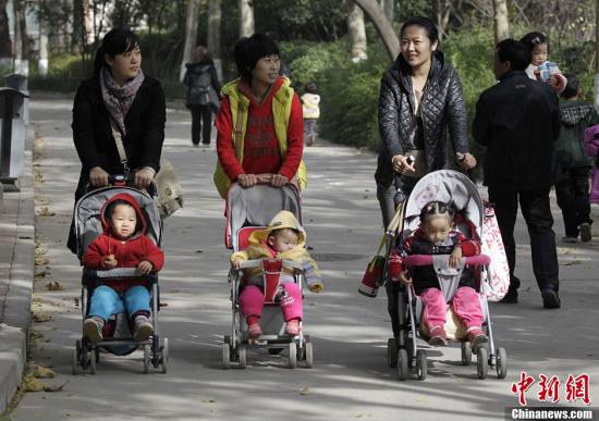 資料圖：2013年11月15日，河南鄭州幾位家長推著嬰兒車走過鄭州街頭。中共十八屆三中全會審議通過了《中共中央關(guān)于全面深化改革若干重大問題的決定》，《決定》提出，啟動實施一方是獨生子女的夫婦可生育兩個孩子的政策。<a target='_blank' href='http://www.chinanews.com/'>中新社</a>發(fā) 王中舉 攝