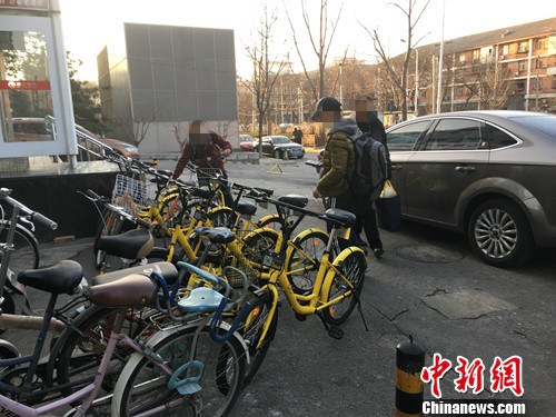 在北京街頭的一處共享單車停車點(diǎn)，有小孩在嘗試解鎖。湯琪 攝