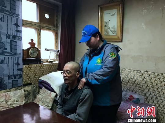 服務(wù)人員幫助殘疾人做按摩。　孫?！z