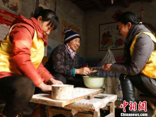 資料圖：除夕，巨鹿縣居家養(yǎng)老服務(wù)中心工作人員王勝晨、陳云彩和失獨(dú)老人張會(huì)群一起包餃子?！⊥醣麖?qiáng) 攝