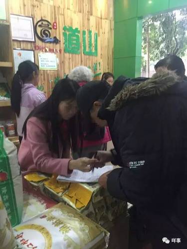 值班的業(yè)務(wù)員正為一名老人登記會(huì)員資料并派發(fā)團(tuán)購(gòu)券。