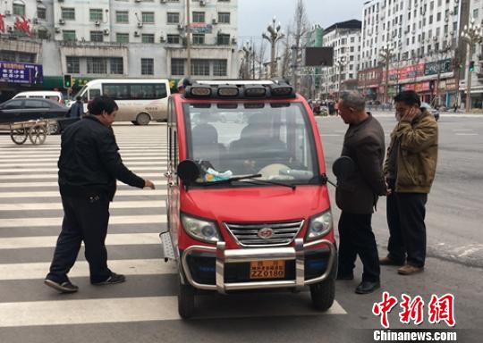 營山城區(qū)電動(dòng)四輪車司機(jī)正在討論車輛的車況?！⒅铱?攝