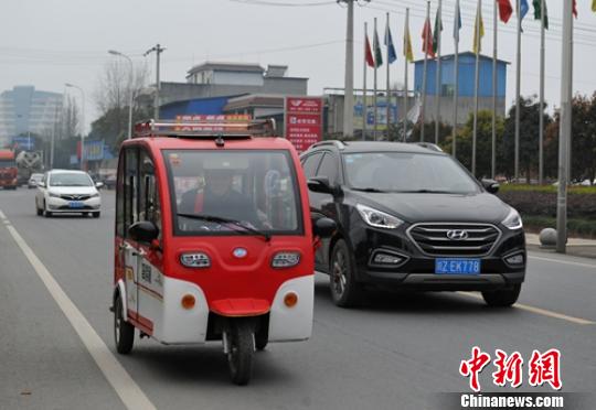 一位老者駕駛電動(dòng)三輪車(chē)行駛在省道103線公路眉山段?！⒅铱?攝