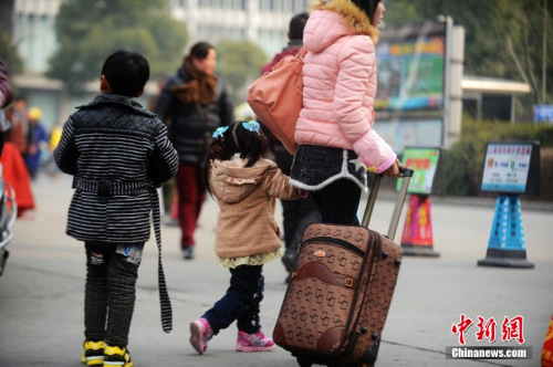 資料圖：2015年2月5日，2015年春運第二天，江蘇揚州市汽車西站迎來客流高峰，圖為家長帶著孩子在江蘇揚州市汽車西站候車。 孟德龍 攝