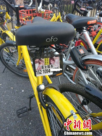 一輛共享單車上的小廣告。<a target='_blank' href='http://www.chinanews.com/' >中新網(wǎng)</a>記者 李金磊 攝