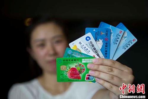 資料圖：民眾展示銀行卡。 <a target='_blank' href='http://www.chinanews.com/'>中新社</a>記者 張?jiān)?攝