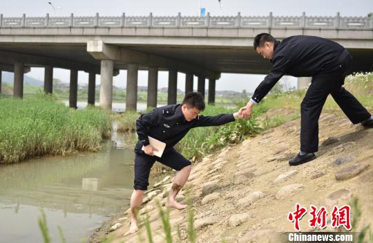圖為：臧建軍勘察河道現(xiàn)場?！⌒蠘芬?攝