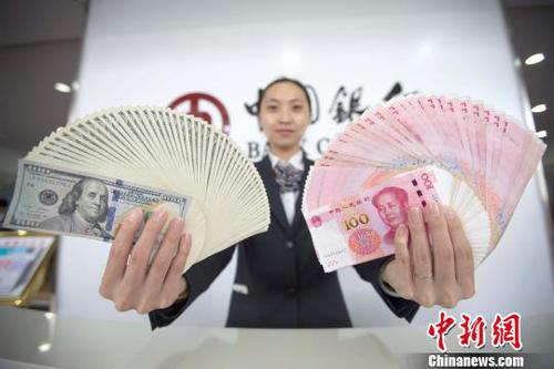 資料圖：山西太原，銀行工作人員展示人民幣、美元?！?jiān)啤z