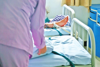 一位病人沉沉睡去，護(hù)士還在為另一位病人整理床鋪。