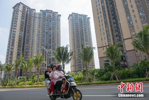 資料圖：市民在?？谑袇^(qū)某地產(chǎn)項目前路過。 <a target='_blank' href='http://www.chinanews.com/'>中新社</a>記者 駱云飛 攝