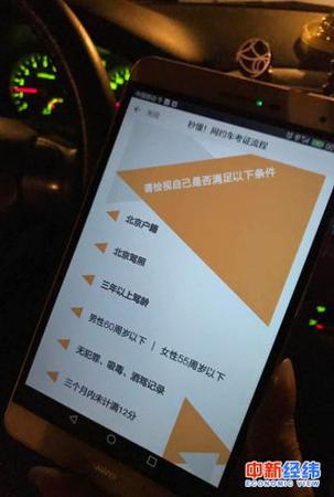 　小李拿手機(jī)展示滴滴平臺(tái)的網(wǎng)約車(chē)司機(jī)標(biāo)準(zhǔn) 中新經(jīng)緯 吳一塵 攝