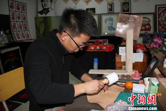 圖為魏康龍正在制作皮雕?！顤|東 攝