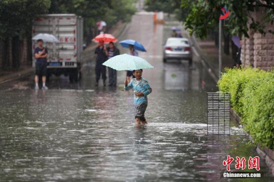 6月12日，市民在積水的道路中出行。當日，貴陽市氣象臺于6時28分將暴雨黃色預警信號升級為暴雨紅色預警信號，持續(xù)降雨造成貴陽市多處路段嚴重積水。<a target='_blank' href='http://www.chinanews.com/'>中新社</a>記者 賀俊怡 攝
