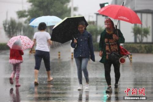 資料圖：民眾在雨中出行。