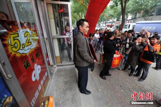 10月11日，在山西太原5.2億元人民幣福彩大獎(jiǎng)?wù)Q生投注站，站主楊文生收到當(dāng)?shù)馗２手行陌l(fā)放的獎(jiǎng)勵(lì)后，引來(lái)周圍民眾的圍觀。10月5日晚，中國(guó)福利彩票雙色球游戲第14115期開(kāi)獎(jiǎng)，當(dāng)期雙色球頭獎(jiǎng)開(kāi)107注，單注獎(jiǎng)金為520.68萬(wàn)元，其中山西獨(dú)攬101注，獎(jiǎng)金高達(dá)5.2億，是中國(guó)彩票史上第三大獎(jiǎng)。一時(shí)間，“買彩票中大獎(jiǎng)”成為當(dāng)?shù)孛癖姺婚g熱議的話題，5.2億福彩大獎(jiǎng)?wù)Q生投注站也成彩民爭(zhēng)相前往的“景點(diǎn)”。中新社發(fā) 韋亮 攝