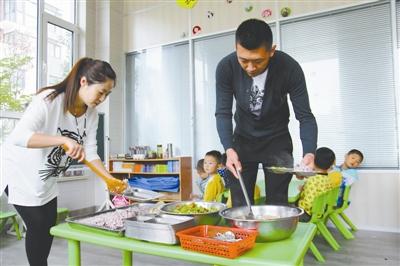 逄秋香、陳亮夫妻倆為幼兒園孩子盛午飯。