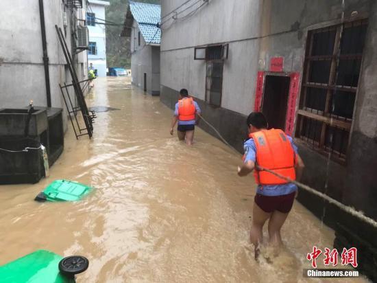 圖為浙江省麗水市遂昌縣民警在積水中準(zhǔn)備營(yíng)救居民。