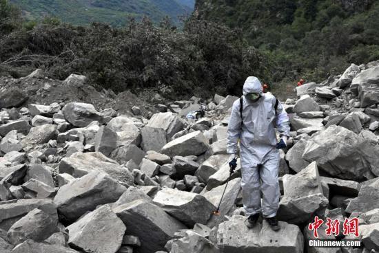 6月26日，四川茂縣疊溪鎮(zhèn)新磨村新村組富貴山“6·24”特別重大山體滑坡災(zāi)害搜救工作進(jìn)入第3天，上千名救援人員堅守現(xiàn)場全力搜救。圖為防疫人員進(jìn)行消毒防疫。 中新社記者 安源 攝