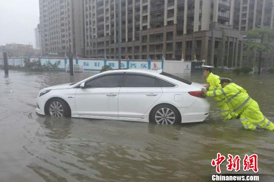 圖為：周宇和隊(duì)員在水中推拋錨的車。 金華公安供圖