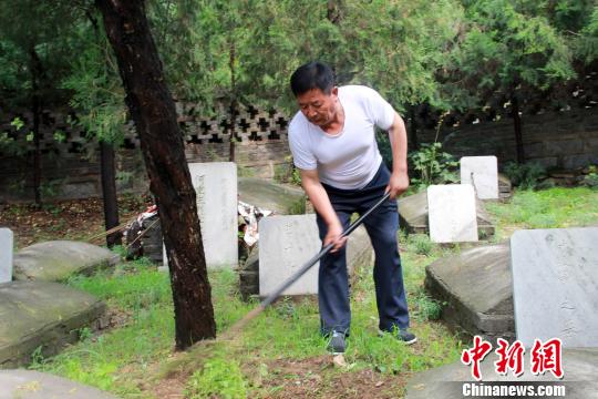 趙玉山在烈士墓園內鋤草。　于俊亮 攝
