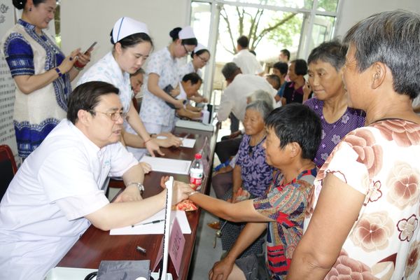 溫建民委員在龍林村民委員會給貧困患者看病。