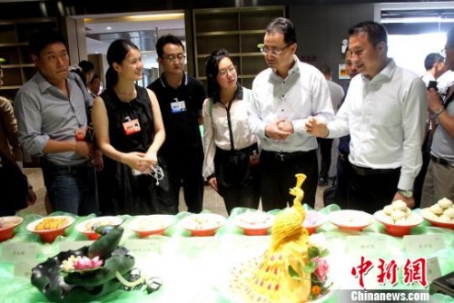  圖為華裔青年在參觀中華美食廚藝?！〈藜衙鳌z