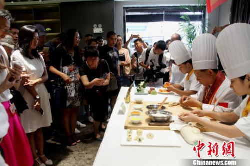圖為烹飪大師現(xiàn)場(chǎng)廚藝表演，令華裔青年贊不絕口?！〈藜衙?攝