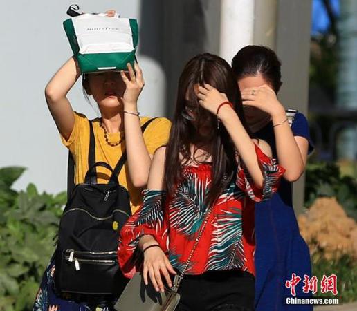 7月20日，武漢高溫持續(xù)，出行的市民用手和隨身物品遮擋陽光。<a target='_blank' href='http://www.chinanews.com/'>中新社</a>記者 張暢 攝