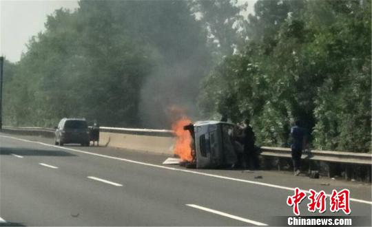 圖為：杭甬高速寧波段一輛面包車側(cè)翻后起火，好心人救一家7口。　何蔣勇 攝