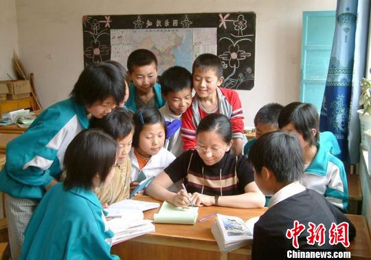 資料圖。圖為張?zhí)m萍給學(xué)生們輔導(dǎo)作業(yè)?！＄娦?攝