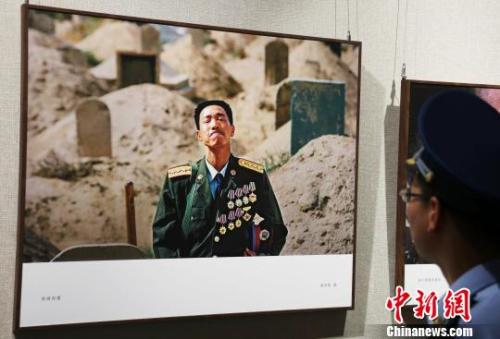 一名部隊官兵正在欣賞攝影作品《英雄探妻》。　劉占昆 攝