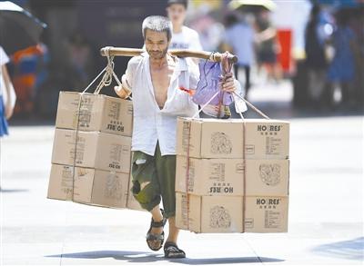 7月28日，一位搬運工在重慶市江北區(qū)觀音橋商圈頂著烈日搬運貨物。 當日，重慶市氣象臺發(fā)布高溫紅色預警信號，多個區(qū)縣的最高氣溫達40℃以上。 新華社記者 王全超 攝